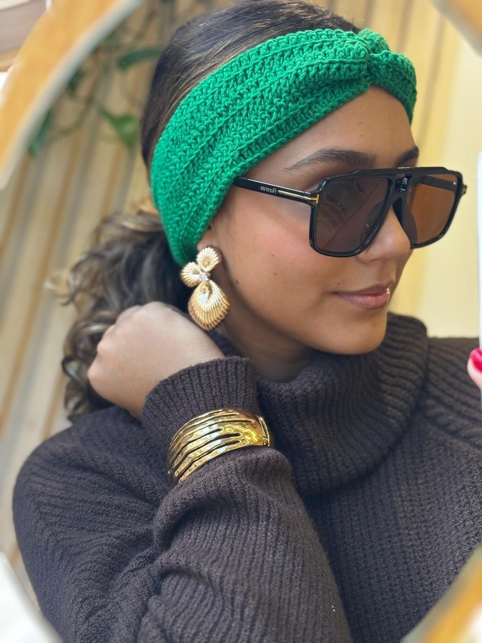 Óculos de sol quadrado preto, faixa de cabelo verde em crochê, brinco concha dourado e pulseira vazada
